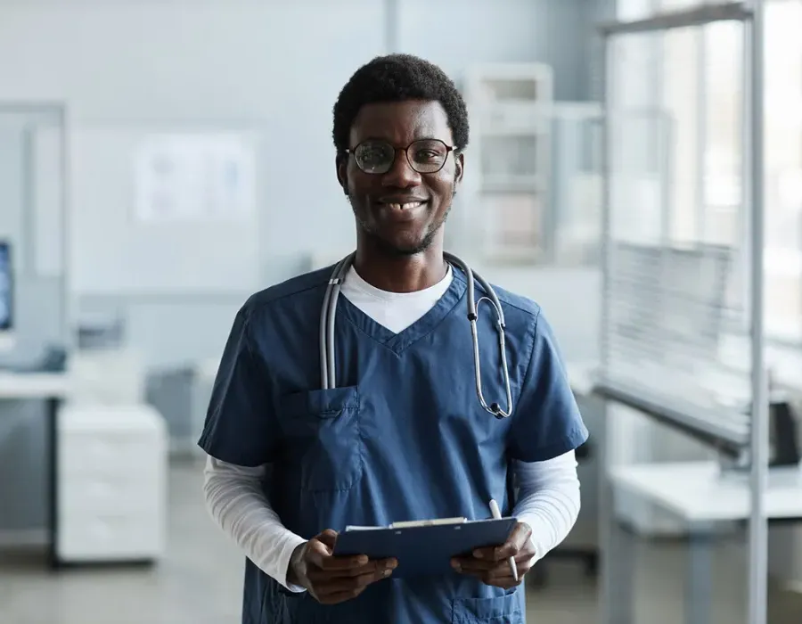 Medical assistant holding clipboard in physician's office